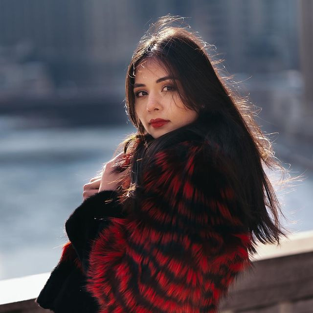 A woman wearing a red and black striped fur coat