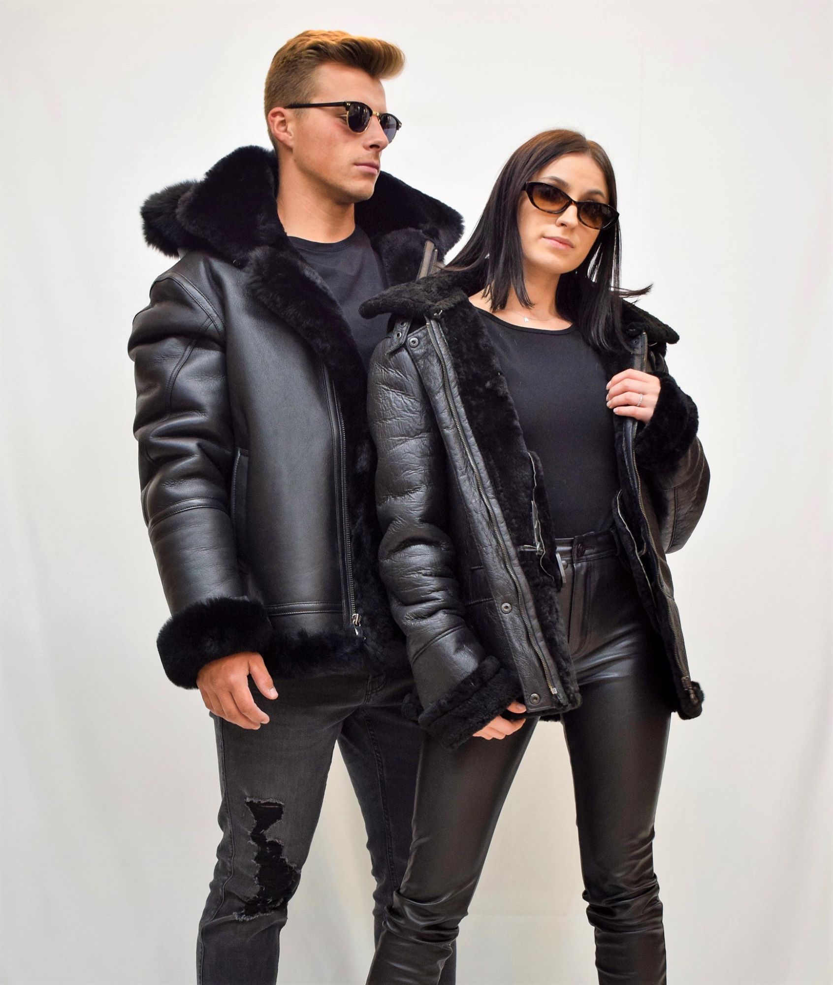 Man and woman both wearing fur lined leather jackets posing together with sunglasses